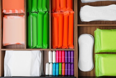 Storage of different feminine hygiene products in wooden organizers, top view