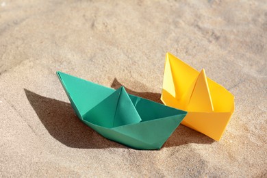 Photo of Two color paper boats on sandy beach