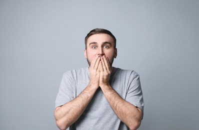 Photo of Young man feeling fear on grey background