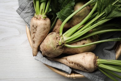 Photo of Basket with fresh sugar beets on white wooden table, top view