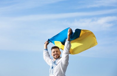 Man in vyshyvanka with flag of Ukraine outdoors