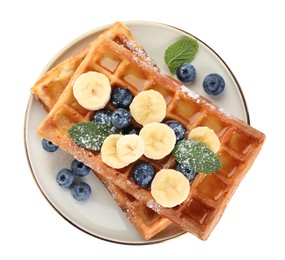 Photo of Delicious Belgian waffles with blueberries and banana on white background, top view