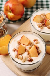 Delicious yogurt with fresh peach and granola on white table, above view