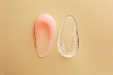 Samples of cosmetic gels on beige background, top view
