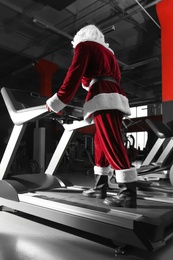 Authentic Santa Claus training on treadmill in modern gym