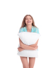 Young woman in pajamas embracing pillow on white background
