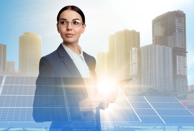 Double exposure of businesswoman with tablet and solar panels installed outdoors. Alternative energy source
