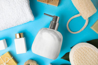 Flat lay composition with marble soap dispenser on light blue background