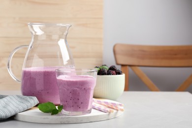 Delicious blackberry smoothie and mint on white table indoors, space for text