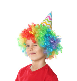 Little boy in clown wig and party hat on white background. April fool's day