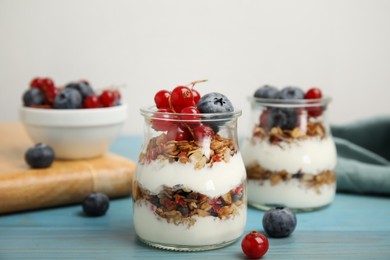 Delicious yogurt parfait with fresh berries on turquoise wooden table