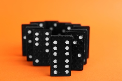 Black domino tiles with white pips on orange background