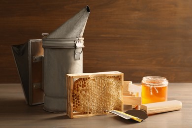 Composition with honeycomb and beekeeping tools on wooden table