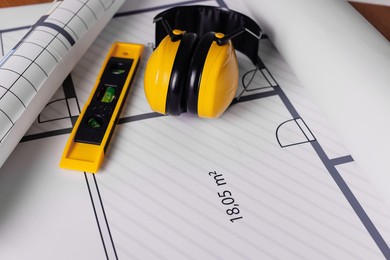 Construction drawings, safety headphones and ruler, closeup view