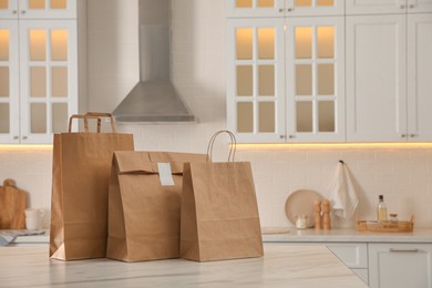 Paper bags on white marble table in kitchen. Space for text