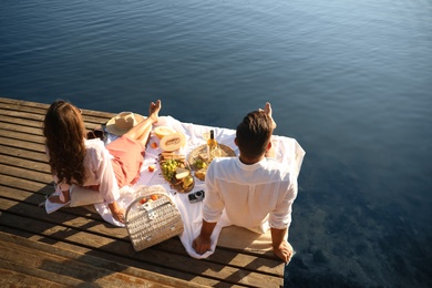 Photo of Happy couple spending time on pier at picnic