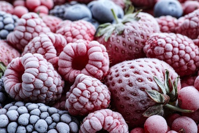 Mix of different frozen tasty berries as background, closeup