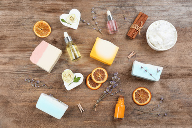 Flat lay composition with natural handmade soap and ingredients on wooden table