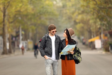 Photo of Couple of travelers with map on city street