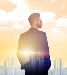 Double exposure of businessman and cityscape on sunset