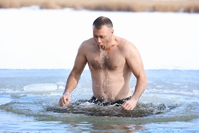 MYKOLAIV, UKRAINE - JANUARY 19, 2021: Man immersing in icy water on winter day. Traditional Baptism ritual