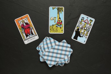 Tarot cards on black table, flat lay
