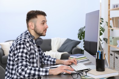 Young man using modern computer for studying at home. Distance learning