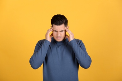 Portrait of stressed man on yellow background