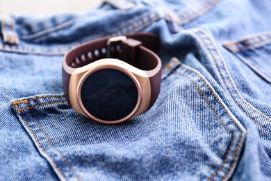Modern stylish smart watch on jeans, closeup