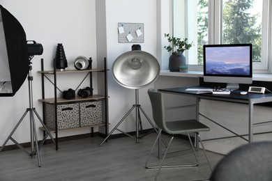 Photo of Professional lighting equipment and comfortable workplace in photo studio. Interior design