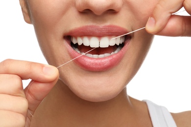 Young woman flossing her teeth on white background, closeup. Cosmetic dentistry