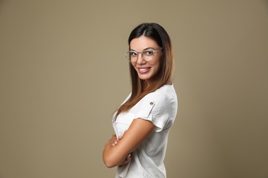 Beautiful woman in eyeglasses on beige background