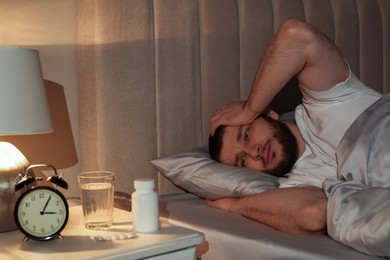 Man suffering from insomnia in bed at night