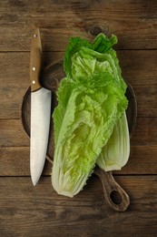Halves of fresh ripe Chinese cabbage and knife on wooden table, flat lay