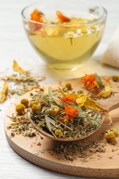 Mix of dried herbs and tea on white wooden table