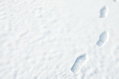 Footprints on white snow outdoors, space for text. Winter weather