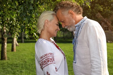 Happy mature couple in Ukrainian national clothes outdoors