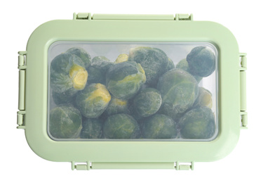 Frozen Brussels sprouts in plastic container isolated on white, top view. Vegetable preservation
