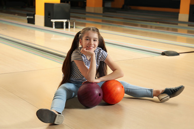 Preteen girl with balls in bowling club