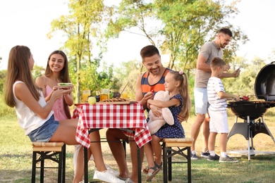 Happy families with little children having picnic in park
