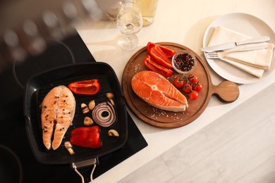 Composition with salmon steaks and vegetables in frying pan, above view