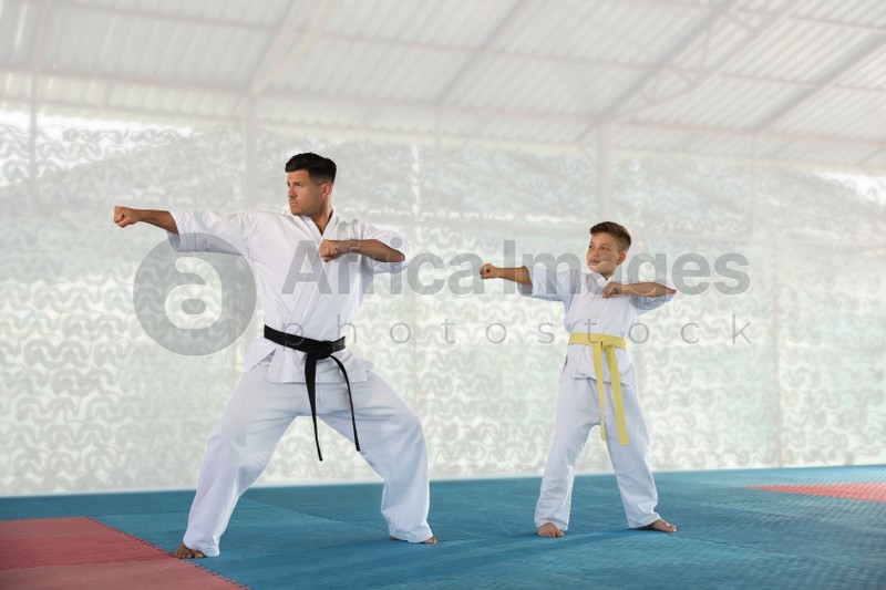 Boy and coach practicing karate at gym