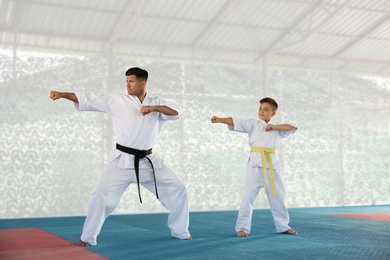 Boy and coach practicing karate at gym