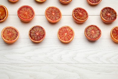 Many ripe sicilian oranges on white wooden table, flat lay. Space for text