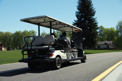 Photo of People in golf cart on road outdoors