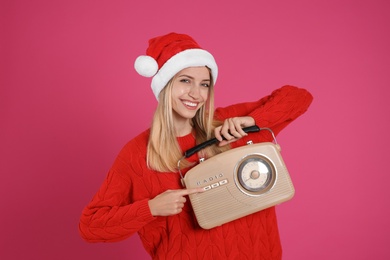 Happy woman with vintage radio on pink background. Christmas music