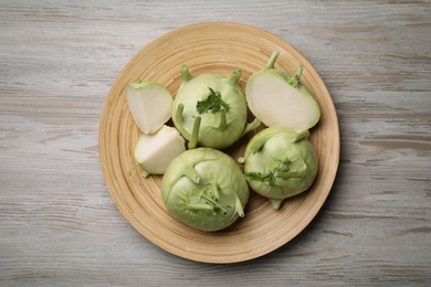 Photo of Whole and cut kohlrabi plants on wooden table, top view