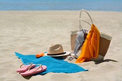 Blue towel, bag and beach accessories on sandy seashore