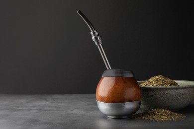 Calabash with mate tea and bombilla on light grey table. Space for text