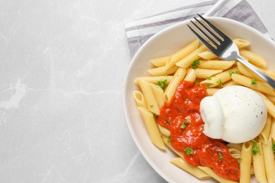 Delicious pasta with burrata cheese and sauce on light grey table, top view. Space for text